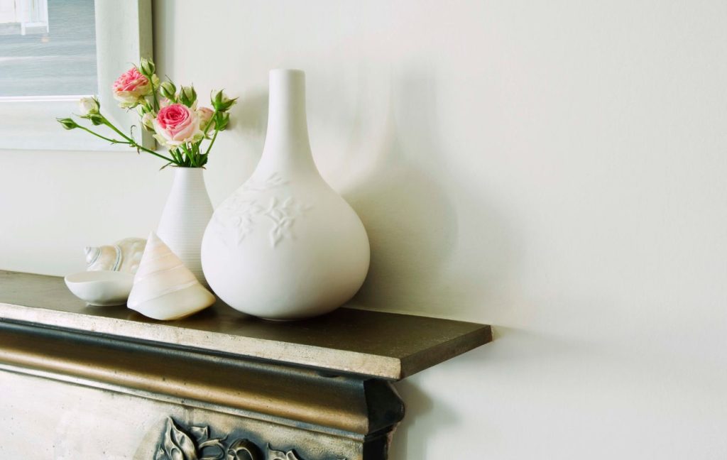 Fireplace Design Ideas: Materials, Colors, Design Styles 3 Add some greenery. Two white vases with pink roses in them on the fireplace mantel.